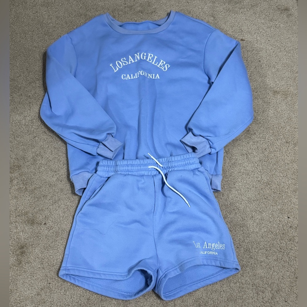 blue embroidered sweatshirt and shorts.